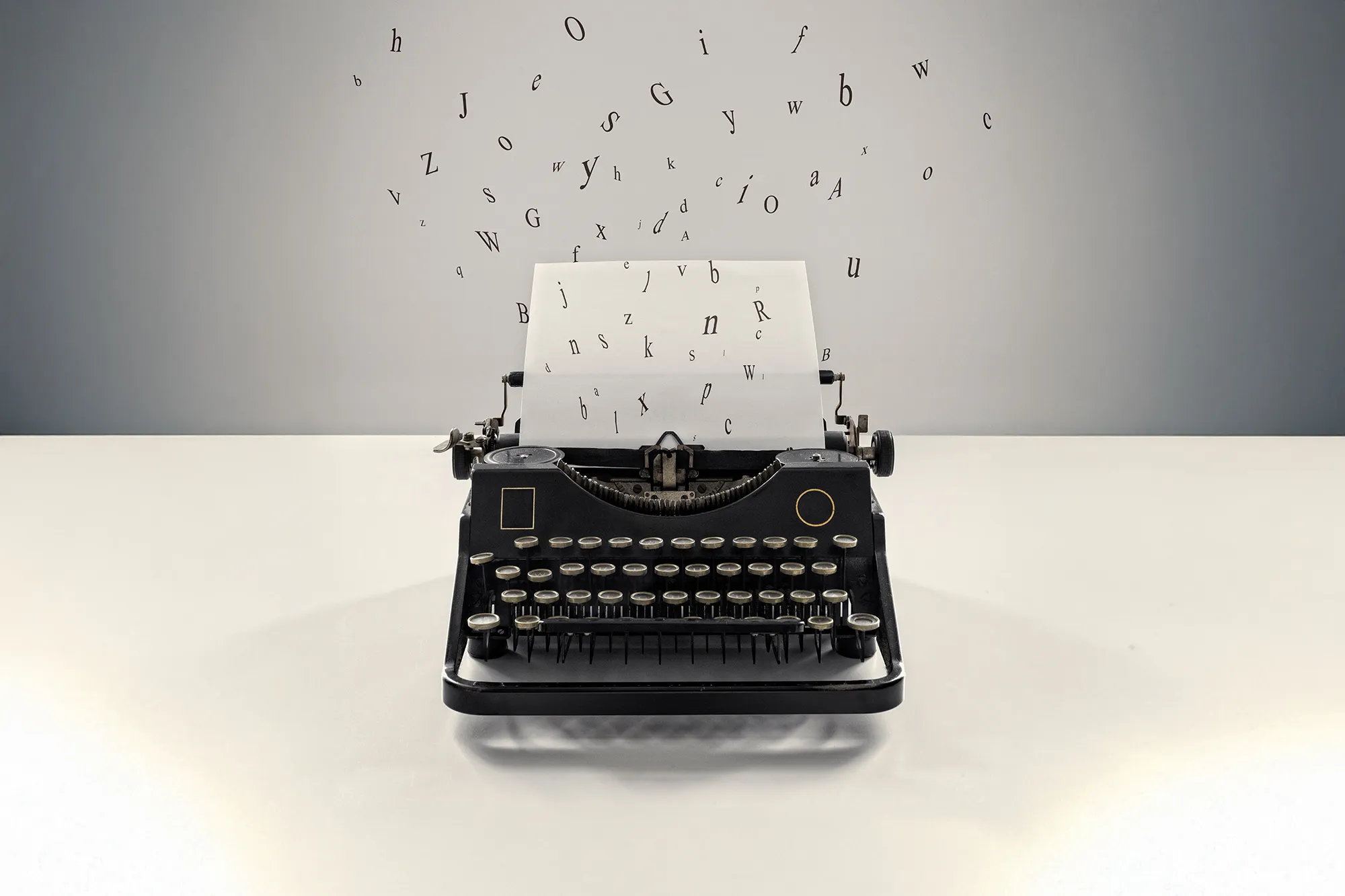 Vintage black typewriter on a desk with loose alphabet letters floating upward, symbolizing writing, creativity, and storytelling.