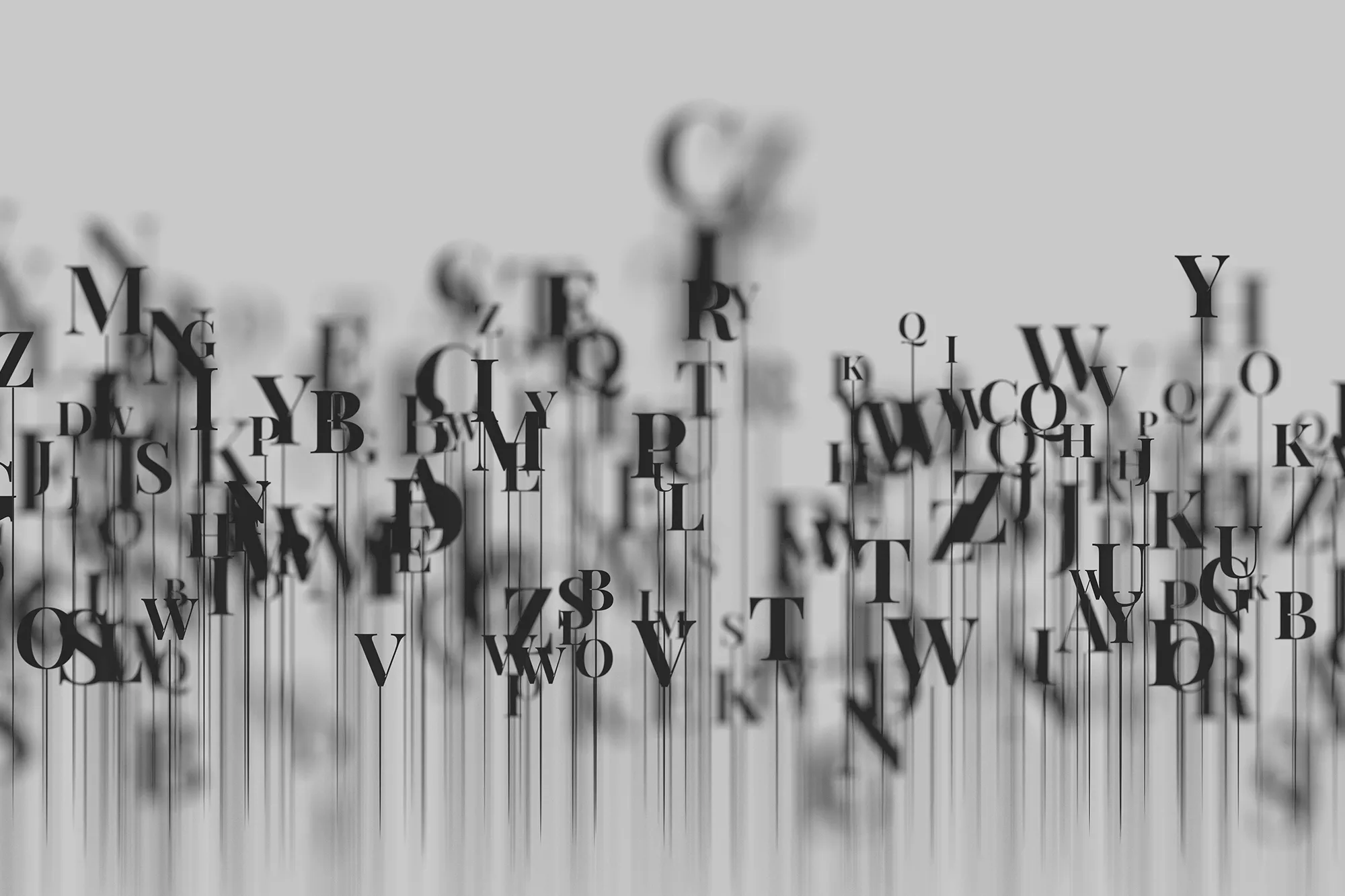 Abstract composition of scattered letters and typography in grayscale, suggesting language, storytelling, and creative writing concepts.