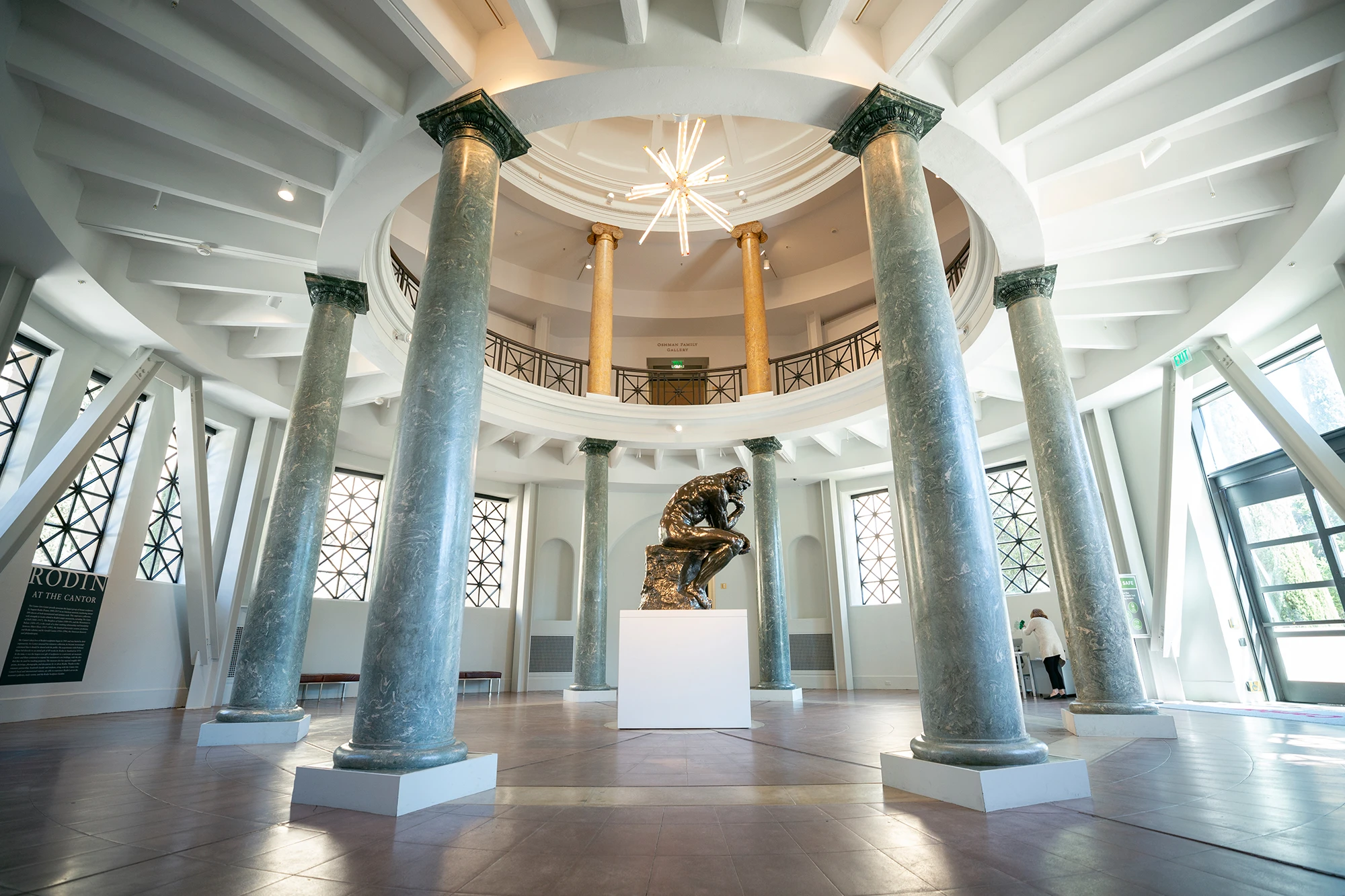 Rodin’s The Thinker displayed beneath a chandelier in the columned rotunda of the Cantor Arts Center.